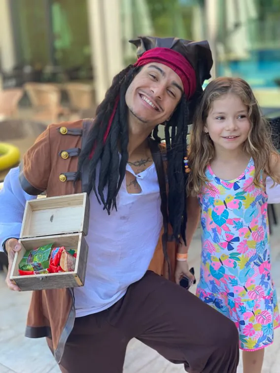 Ted vestido de pirata com uma criança junto a uma arca do tesouro